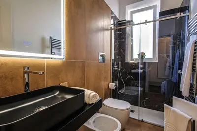 a bathroom with a sink and a toilet and a shower at Suites Santa Cecilia in Palermo