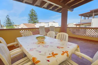 a table and chairs on a balcony with a bowl on it at Casa vacanza Onda Lunga in Alcamo