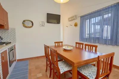 a dining room with a wooden table and chairs at Casa vacanza Onda Lunga in Alcamo