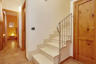a staircase in a house with a wooden door at Casa vacanza Onda Lunga in Alcamo