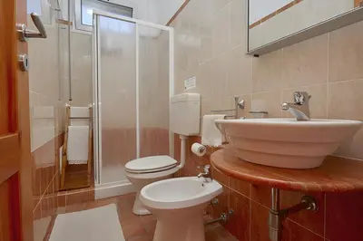 a bathroom with a sink and a toilet and a shower at Casa vacanza Onda Lunga in Alcamo