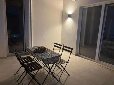 a table and chairs with a bowl of fruit on a balcony at Casa Miramara Sicilia in Balestrate