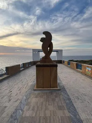 a statue sitting on a pier next to the ocean at Casa Miramara Sicilia in Balestrate