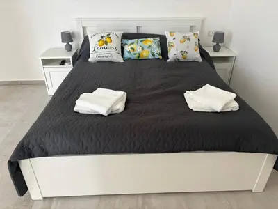 a bedroom with a large bed with black sheets and pillows at Casa Miramara Sicilia in Balestrate