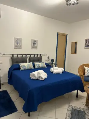 a bedroom with a blue bed with towels on it at Sweet World in Terrasini