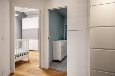 a hallway with white cabinets and a crib in a room at Mani San Domenico by DomuSicily in Palermo
