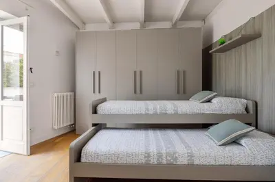 two beds in a room with white cabinets at Mani San Domenico by DomuSicily in Palermo