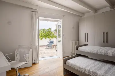 a bedroom with two beds and a desk and a chair at Mani San Domenico by DomuSicily in Palermo