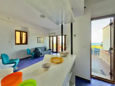 a kitchen and living room with a view of the ocean at Merlo Holiday Homes Mare in Trabia