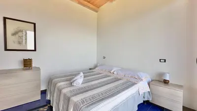 a bedroom with a bed and two dressers at Merlo Holiday Homes Mare in Trabia