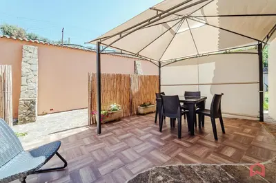 a patio with a table and chairs and an umbrella at Huge Villa with Stunnig Pool in Partinico