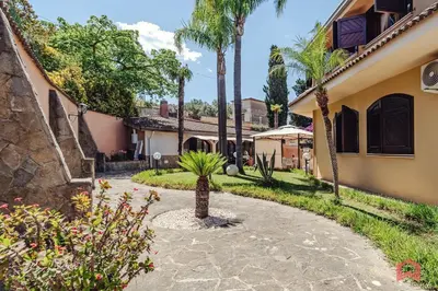 a courtyard of a house with a palm tree at Huge Villa with Stunnig Pool in Partinico
