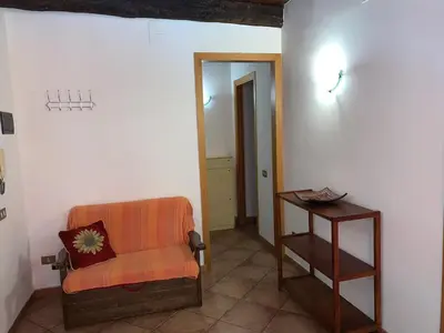 a living room with an orange chair and a table at Casa Ballarò Centro Storico in Palermo