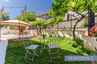 a patio with two chairs and a table and an umbrella at Baida Apartments in Palermo