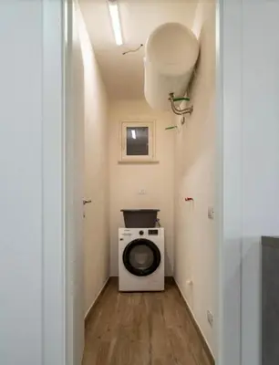 a laundry room with a washing machine and a window at Villa a due passi dal mare in Mandra Capreria
