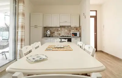 a white table and chairs in a kitchen at Villa a due passi dal mare in Mandra Capreria