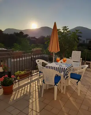 a table with chairs and an umbrella on a patio at Oasi Mondello in Mondello