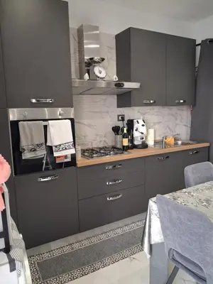 a kitchen with gray cabinets and a stove top oven at Stella Mare in Santa Flavia
