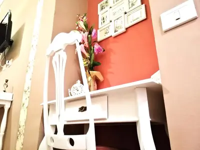 a white chair in front of a wall with flowers at B&B Centro900 in Palermo