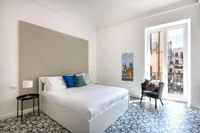 a white bedroom with a bed and a window at Ci' Capo Apartments by Wonderful Italy in Palermo