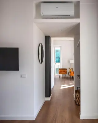 a living room with white walls and a flat screen tv at Ci' Capo Apartments by Wonderful Italy in Palermo