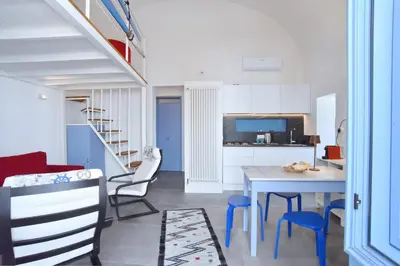 a kitchen and living room with a table and chairs at Re mare exclusive home in Terrasini