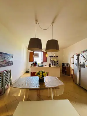 a kitchen with a table and two hanging lights at Villa Giulia Maria in Alcamo