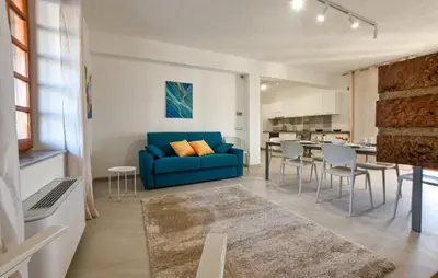 a living room with a blue couch and a kitchen at Villa Anastasia in Partinico