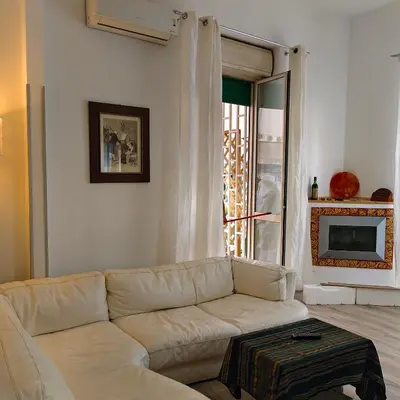 a living room with a white couch and a tv at Sedie Volanti Classy Home in Palermo