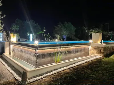 a swimming pool at night with lights at Levriero1 in Carini