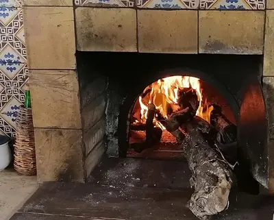 a pizza oven with a fire in it at Levriero1 in Carini