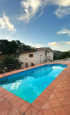 a large blue swimming pool in front of a house at Villa con Piscina in Ventimiglia di Sicilia