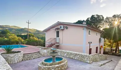 a small house with a fountain in front of it at Villa con Piscina in Ventimiglia di Sicilia