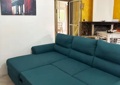 a blue couch in a living room with a fireplace at Villa con Piscina in Ventimiglia di Sicilia