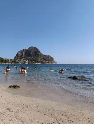 a group of people swimming in the water at the beach at Villino Rosa in Santa Flavia