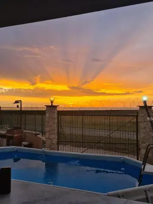 a swimming pool with a sunset in the background at Casa Nadiia in Cinisi