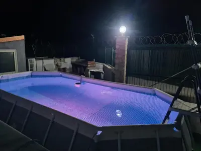 a swimming pool lit up at night with a light at Casa Nadiia in Cinisi