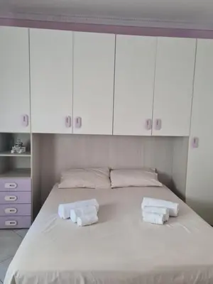 a white bedroom with two towels on a bed at Casa Nadiia in Cinisi