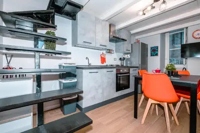 a kitchen with a dining table and orange chairs at Marta's Home in Palermo