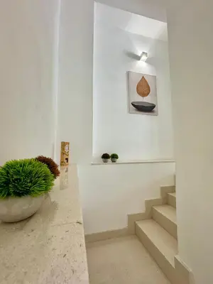 a staircase in a white room with a potted plant at TerrAmata in Terrasini