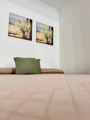 a room with three paintings on the wall with a bed at TerrAmata in Terrasini