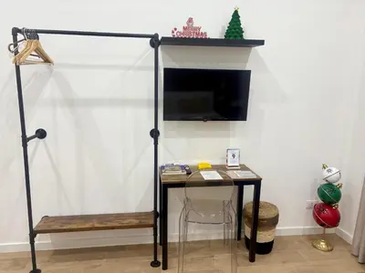 a room with a desk with a tv and a table at Suite 196 - Central City Palermo in Palermo