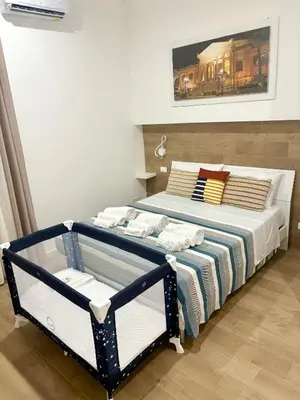 a bedroom with a bed with a blue and white blanket at Suite 196 - Central City Palermo in Palermo