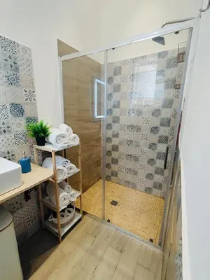 a shower with a glass door in a bathroom at D'anthoine apartment in Palermo