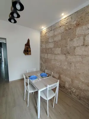 a table and chairs in a room with a brick wall at D'anthoine apartment in Palermo