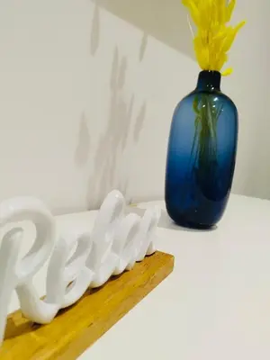 a blue vase and a white object next to a wooden shelf at D'anthoine apartment in Palermo