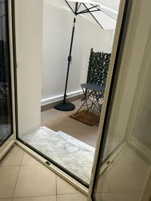 a glass door with a view of a room with a lamp at Florio Rooms in Palermo