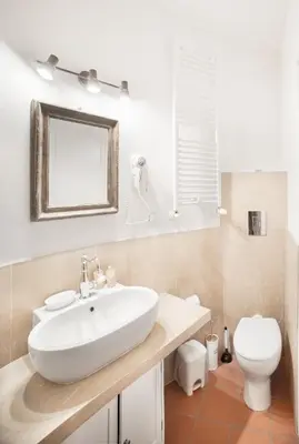 a bathroom with a white sink and a toilet at Torre Lanza di Guidaloca By DomuSicily in Castellammare del Golfo