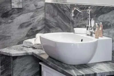 a bathroom with a white sink on a counter at Torre Lanza di Guidaloca By DomuSicily in Castellammare del Golfo