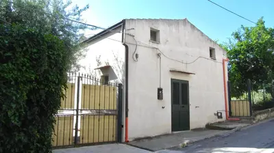 a white building with a gate and a fence at Da Sandra in Trabia